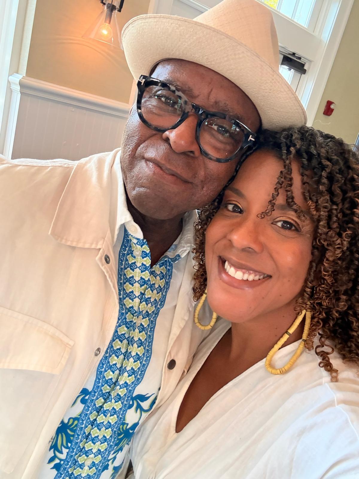 Jinan O'Connor smiling beside an elder in a straw hat