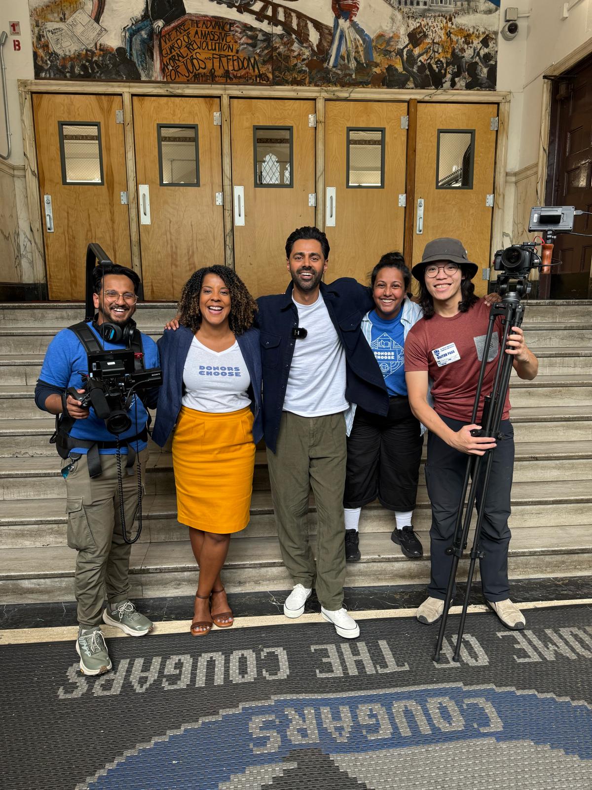 Jinan O'Connor with a film crew and collaborators on the steps of a school